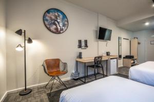 a hotel room with a bed and a desk with a computer at Nightcap at Keysborough Hotel in Keysborough