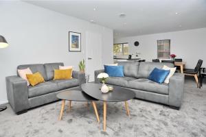 a living room with a couch and a table at Regents Villas - Christchurch Holiday Homes in Christchurch