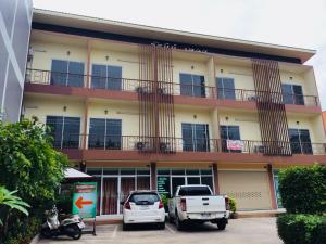 a building with cars parked in front of it at Ratchanee Place in Chaiyaphum