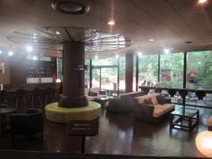 a restaurant with a lobby with couches and a bar at Kikuchi Kanko Hotel in Kikuchi