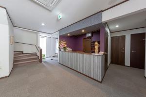 un vestíbulo de oficina con barra y paredes púrpuras en Pension Lavender en Furano