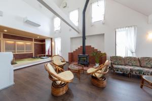 a living room with a couch and chairs and a fireplace at Pension Lavender in Furano