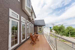 a balcony of a house with a table and chairs at Pension Lavender in Furano