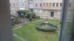 a view of a garden from a window at Bonhome Posío Termal in Ourense