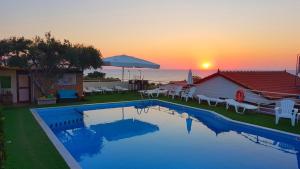 a swimming pool with a sunset in the background at View Villas in Hersonissos