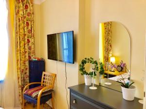 una camera con cassettiera e televisione appesa a un muro di Sharm Sweet Studio City Center Kamppi 49 Kalevankatu a Helsinki