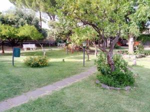 a park with a tree and a sidewalk at Studio Apartment with garden and free parking in Giardini Naxos