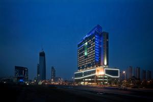 a tall building with blue lights on it at night at Bridge Hotel Incheon Songdo in Incheon