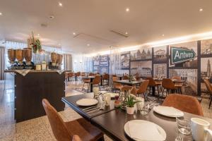 uma sala de jantar com mesas e cadeiras num restaurante em Astoria Hotel Antwerp em Antuérpia