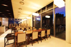 仁川的住宿－Bridge Hotel Incheon Songdo，一间带长桌和椅子的用餐室