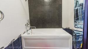 a white bath tub in a bathroom with a window at Dekabrist Apartment Belika 13 in Chita