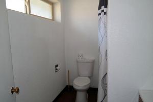 a small bathroom with a toilet and a window at River Park Inn in Klamath Falls