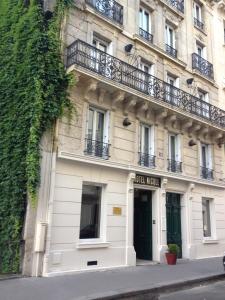 Großes weißes Gebäude mit Balkon in der Unterkunft Hotel Pierre Nicole in Paris