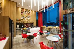 ein Restaurant mit roten Stühlen und Tischen und eine Bar in der Unterkunft Travelodge Dongdaemun Seoul in Seoul