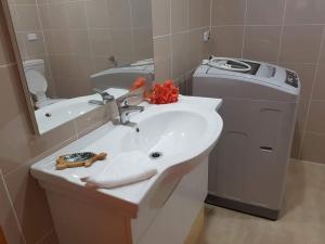 a bathroom with a sink and a trash can at Tavake Villa in Arutanga