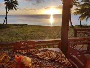 a bed on a porch with a view of the ocean at Tavake Villa in Arutanga