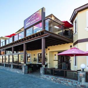 a restaurant with an umbrella in front of a building at Hotel Deutsches Haus Swakopmund in Swakopmund
