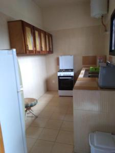 a small kitchen with a stove and a refrigerator at Les pélerins in Pointe-Noire