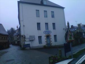 a white building with a sign on the side of it at Les Chambres d'Hôtes de l'Elysée in Pontrieux