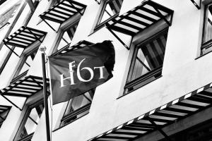 a flag flying in front of a building with windows at Hotel F6 in Helsinki