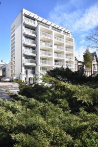 a large white building with trees in front of it at Perła Bałtyku in Świnoujście