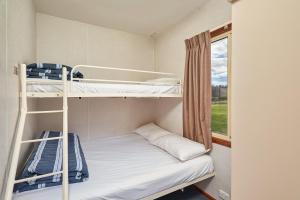 a bedroom with a bed and a window at Gundagai Cabins & Tourist Park in Gundagai