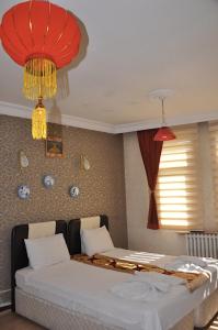 a bedroom with a bed and two chandeliers at MEVLANA ŞEMS HOTEL in Konya