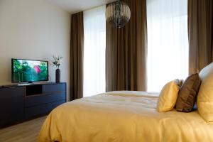 een slaapkamer met een bed en een televisie. bij vienna westside apartments - contactless check-in in Wenen