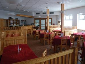 uma sala de jantar com mesas vermelhas e cadeiras num restaurante em Horská chata Sedmidolí em Spindleruv Mlyn