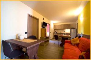 a kitchen and living room with a table and a couch at Mery Livigno in Livigno