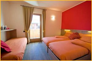 a room with two beds and a window with at Mery Livigno in Livigno
