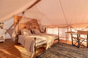 um quarto com uma cama numa tenda em Plage Cachée - Glamping em Vrboska