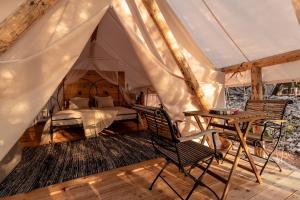 um quarto numa tenda com uma cama e uma mesa em Plage Cachée - Glamping em Vrboska