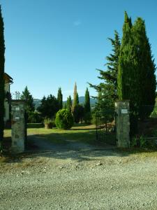 una puerta en un patio con un árbol y árboles en Santa Margherita, en Castiglione dʼOrcia