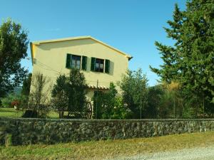 uma casa com uma parede de pedra em frente a uma casa em Santa Margherita em Castiglione dʼOrcia