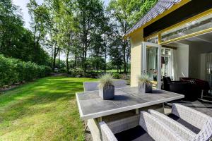 eine Terrasse mit einem Tisch und Stühlen auf einem Haus in der Unterkunft Buitenplaats Gerner in Dalfsen