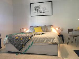 
a bedroom with a bed, a lamp and a painting on the wall at Signature on Gunn in Devonport
