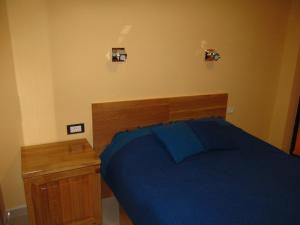 a bedroom with a blue bed and a wooden headboard at Apartment 9 Gorska Vila in Zlatibor