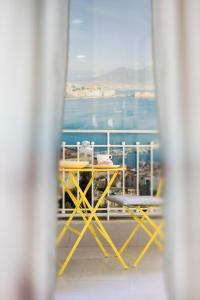 een tafel en stoelen op een balkon met uitzicht op de oceaan bij La Casa di Luna in Napels
