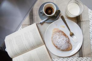 a plate of bread and a cup of coffee and a book at La Casa di Luna in Naples