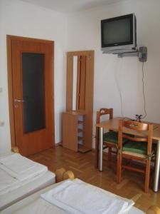 een kamer met een tafel en een tv aan de muur bij Villa Afrodita in Ohrid