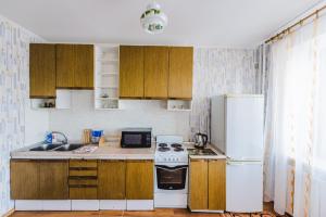チタにあるDekabrist Apartment Oktyabrskiのキッチン(木製キャビネット、白い冷蔵庫付)