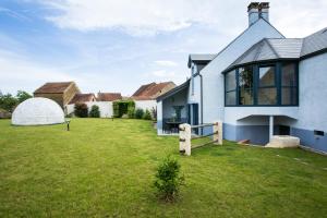 a white house with a greenhouse in the yard at Maison Indigo in Athie