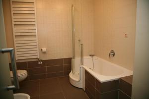 a bathroom with a tub and a toilet and a sink at Hotel Zlaty Dukat in Košice