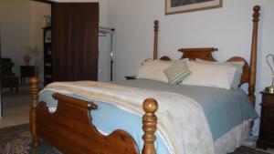 1 dormitorio con 1 cama con marco de madera en Sandalmere Cottage en Cadell