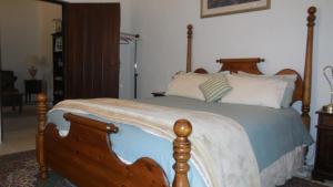 a bedroom with a bed with a wooden frame at Sandalmere Cottage in Cadell