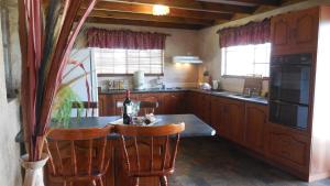 a kitchen with a table with a bottle of wine at Sandalmere Cottage in Cadell +7 photos