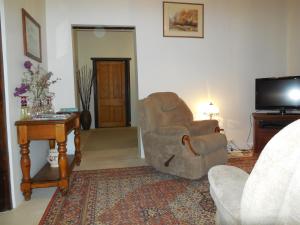 a living room with a chair and a television at Sandalmere Cottage in Cadell