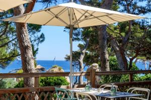 a table with an umbrella in front of the ocean at Village Club Miléade Carry-le-Rouet in Carry-le-Rouet