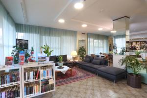 un soggiorno con divano e libreria di Hotel Marselli a Rimini